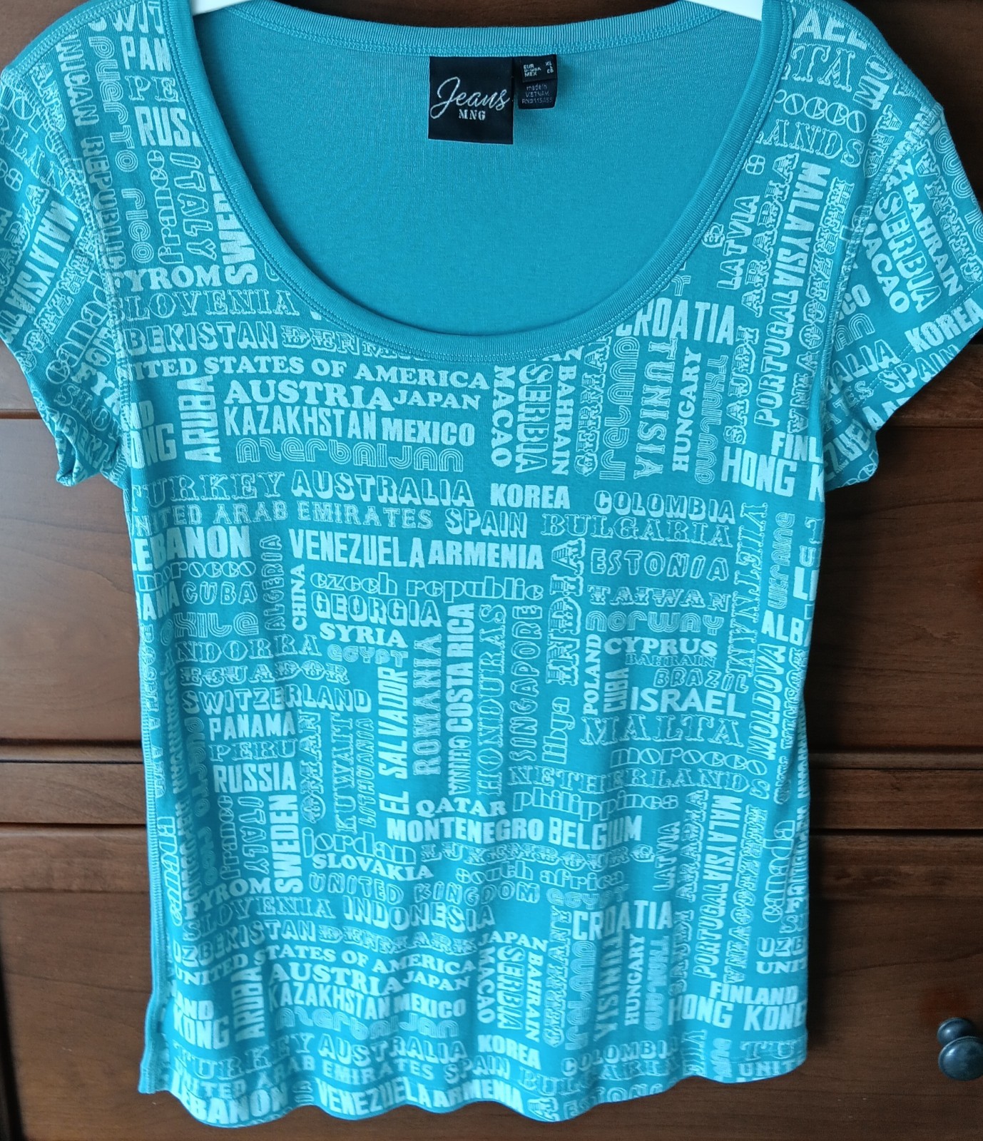 NMG Women’s Shirt NWOT Short Sleeves Scoop Neck Teal w Countries Names on Front
